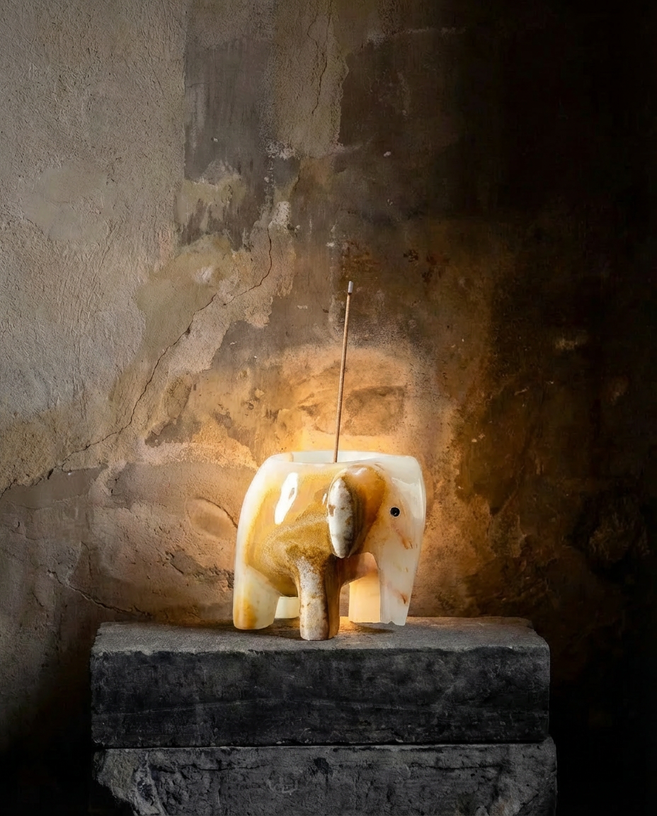 Decorative stone animal sculpture on a pedestal against a textured wall.