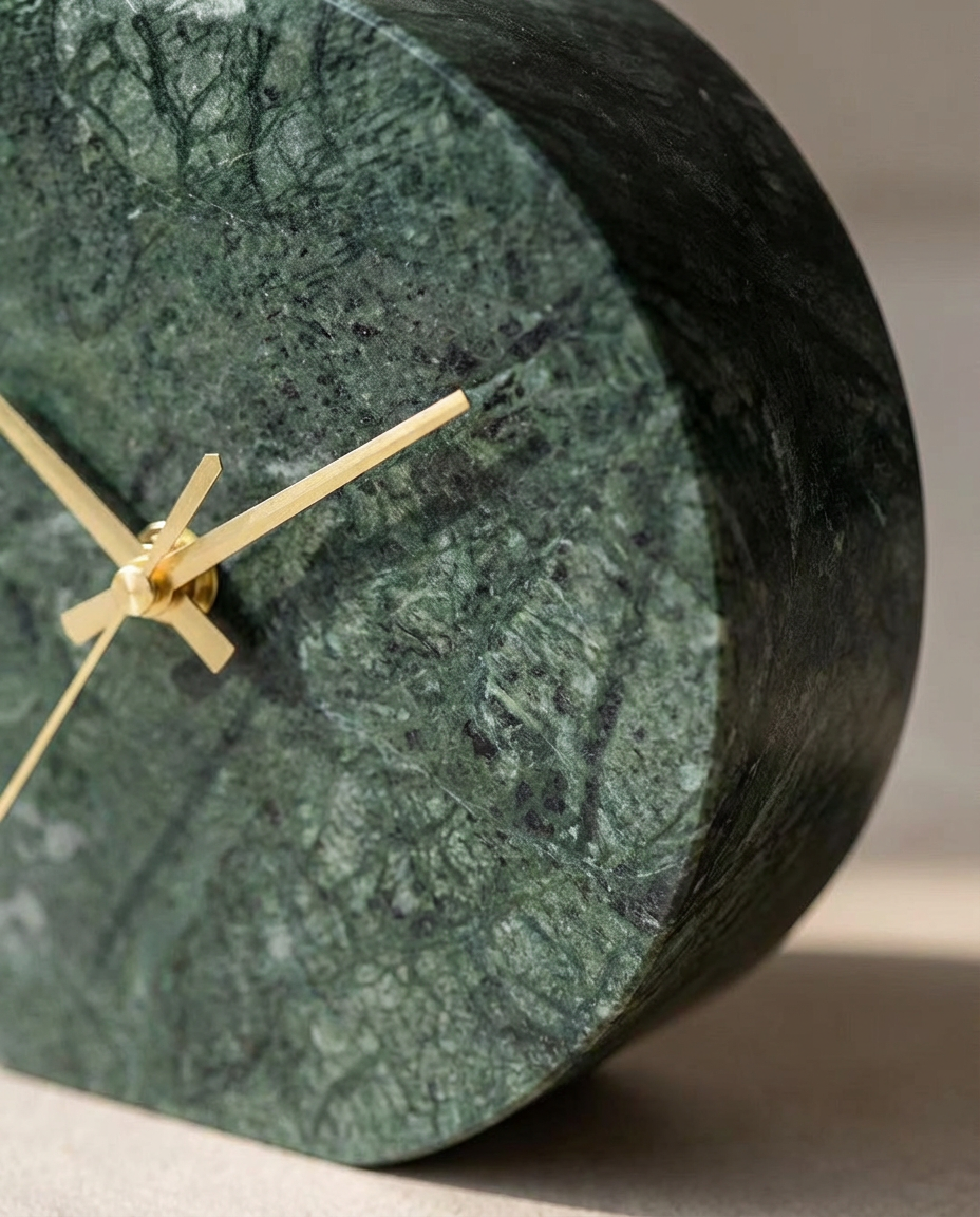 Green marble clock with gold hands on a neutral background