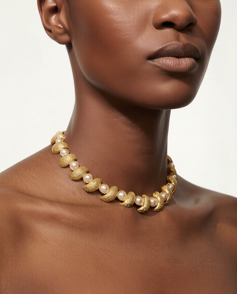 Gold and pearl necklace on a model against a neutral background