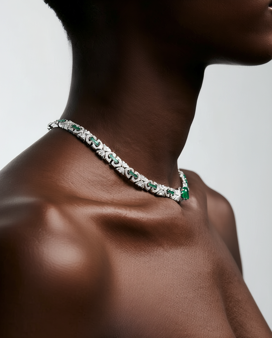 Necklace with green gemstones on a person against a neutral background
