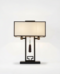 Decorative table lamp with a black base and beige shade on a white background