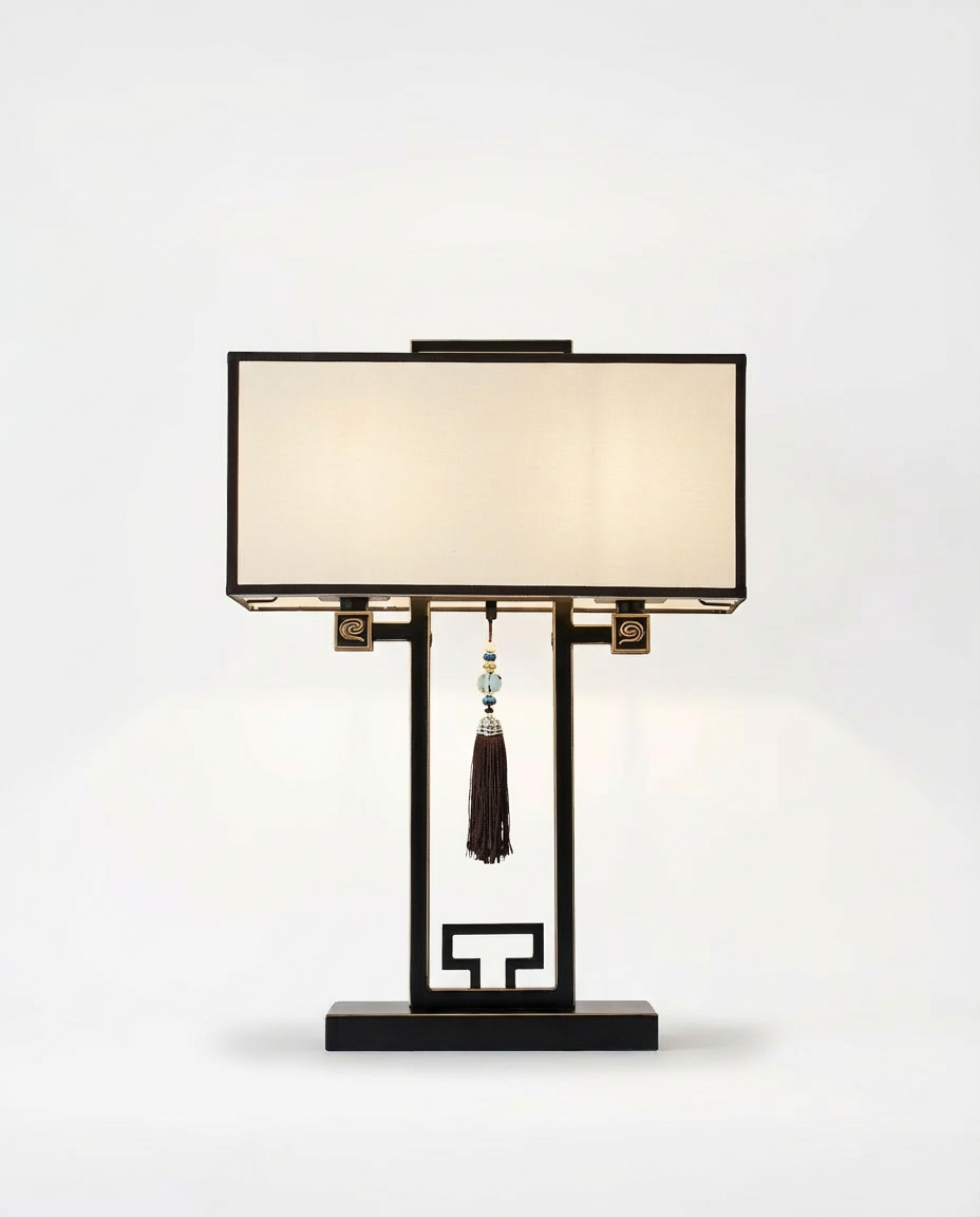 Decorative table lamp with a black base and beige shade on a white background
