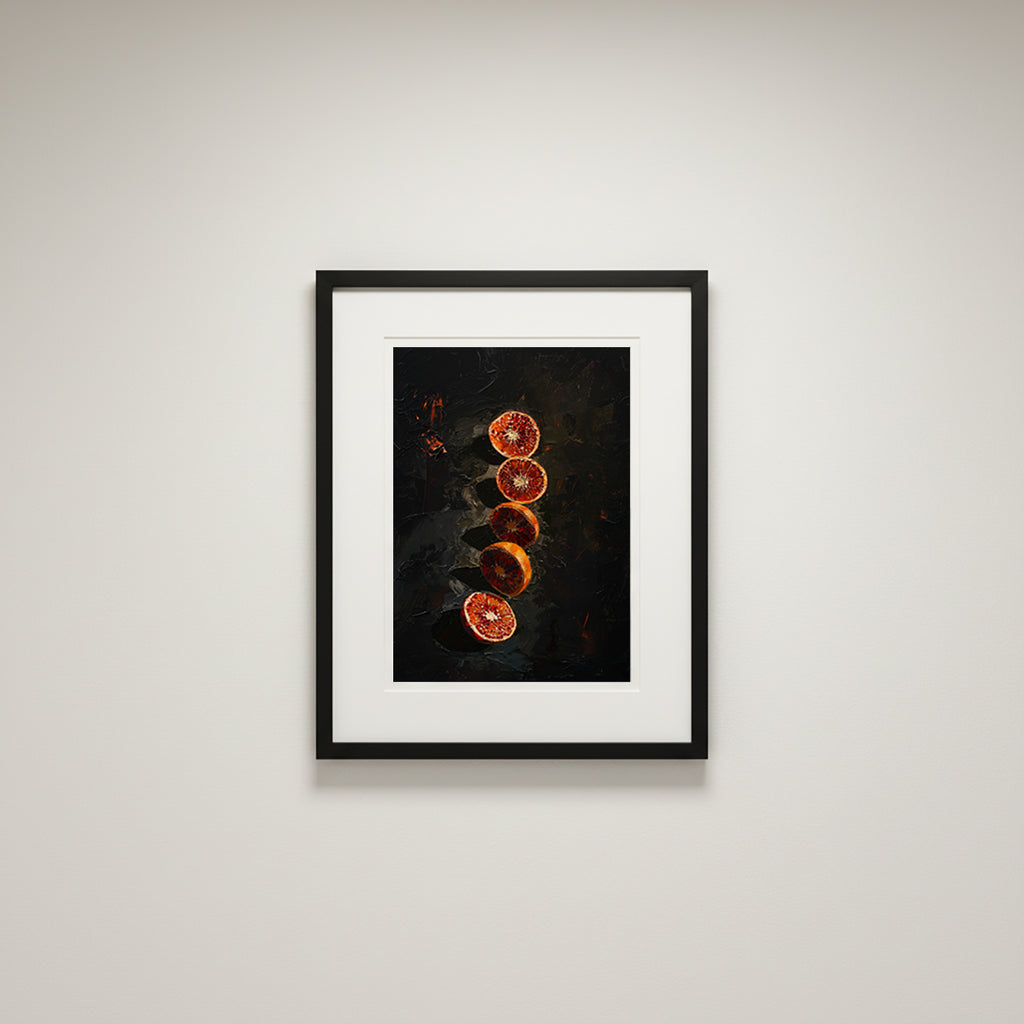 Framed artwork of sliced oranges on a dark background, displayed on a light gray wall.