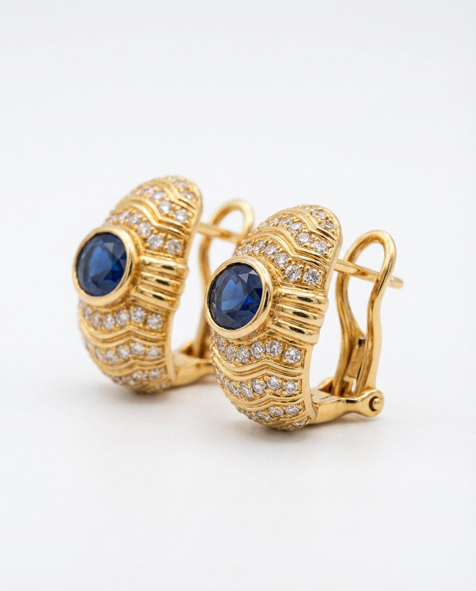 Gold earrings with blue gemstones and diamond accents on a white background