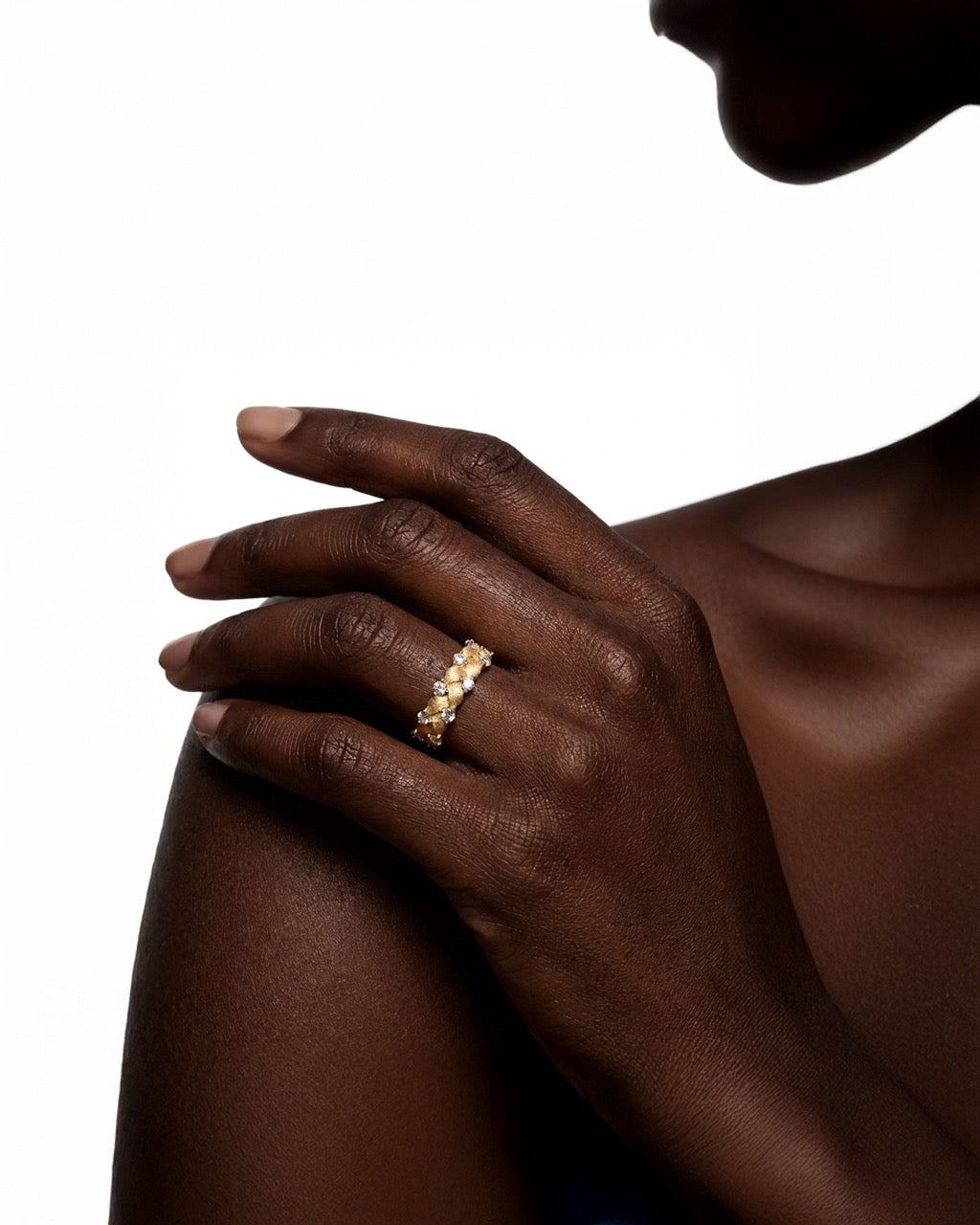 Hand wearing a gold ring on a white background