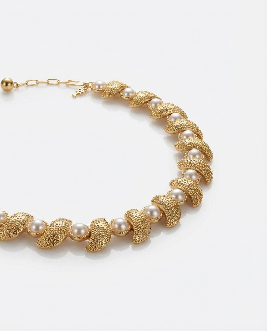 Gold necklace with pearl-like beads on a white background