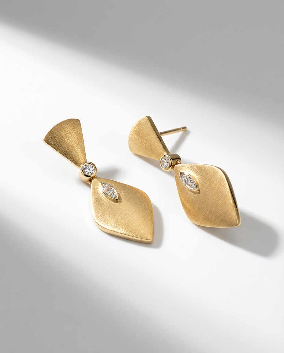 Gold earrings with diamond accents on a light gray background