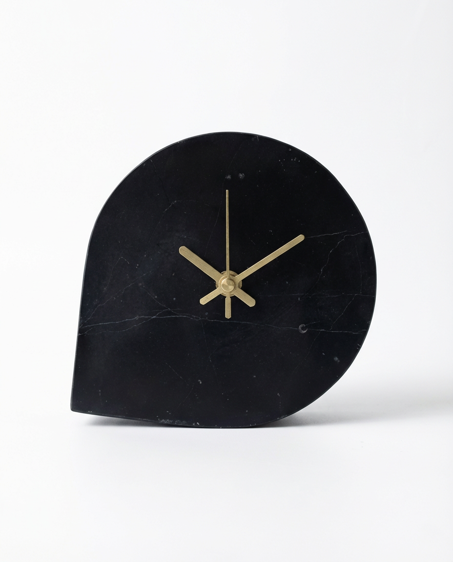 Black marble clock with gold hands on a white background