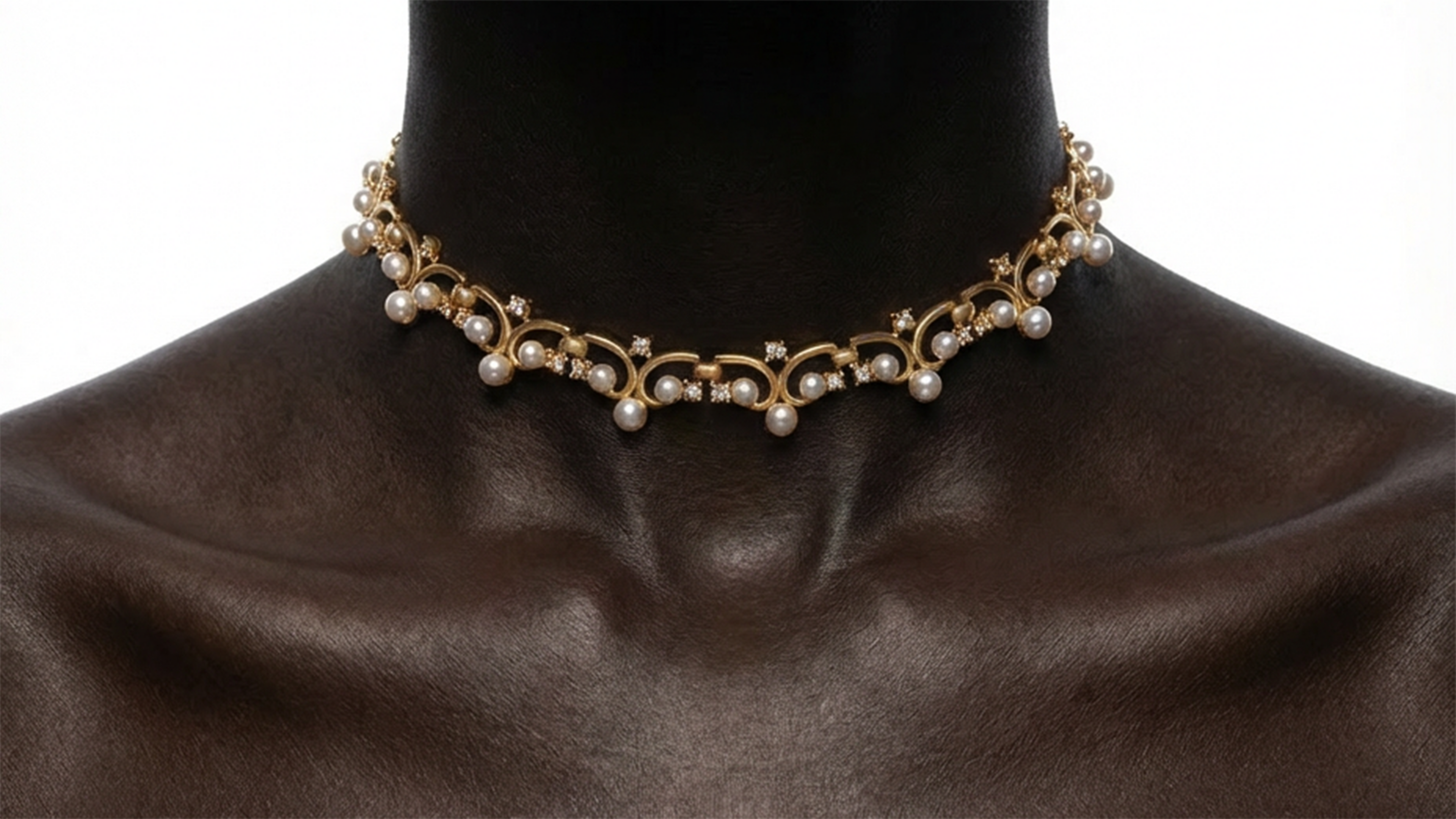 Pearl choker necklace on a mannequin with a brown fabric background