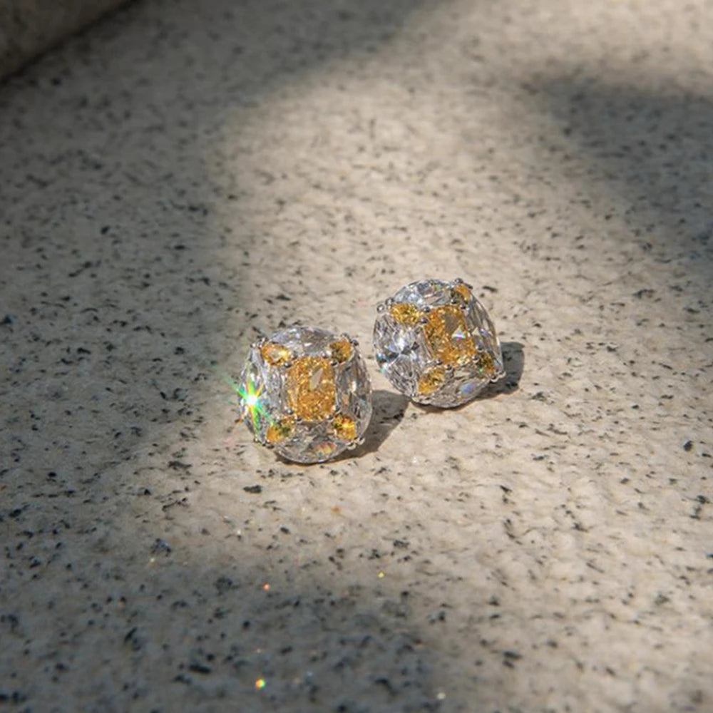 Two diamond earrings on a textured surface
