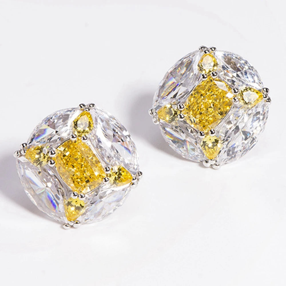 Pair of diamond earrings with yellow and clear stones on a white background