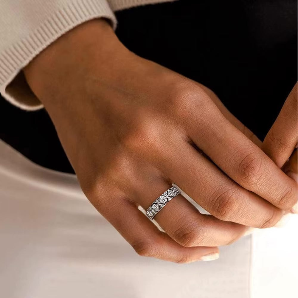 Hand wearing a diamond ring with a neutral background