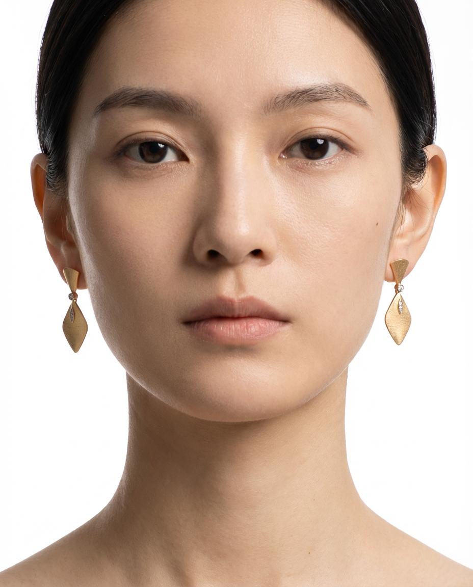 Close-up of a woman wearing gold earrings on a white background
