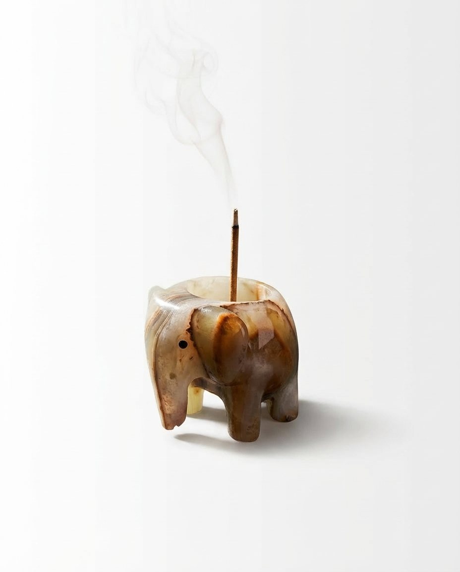 Elephant-shaped incense holder with smoke on a white background