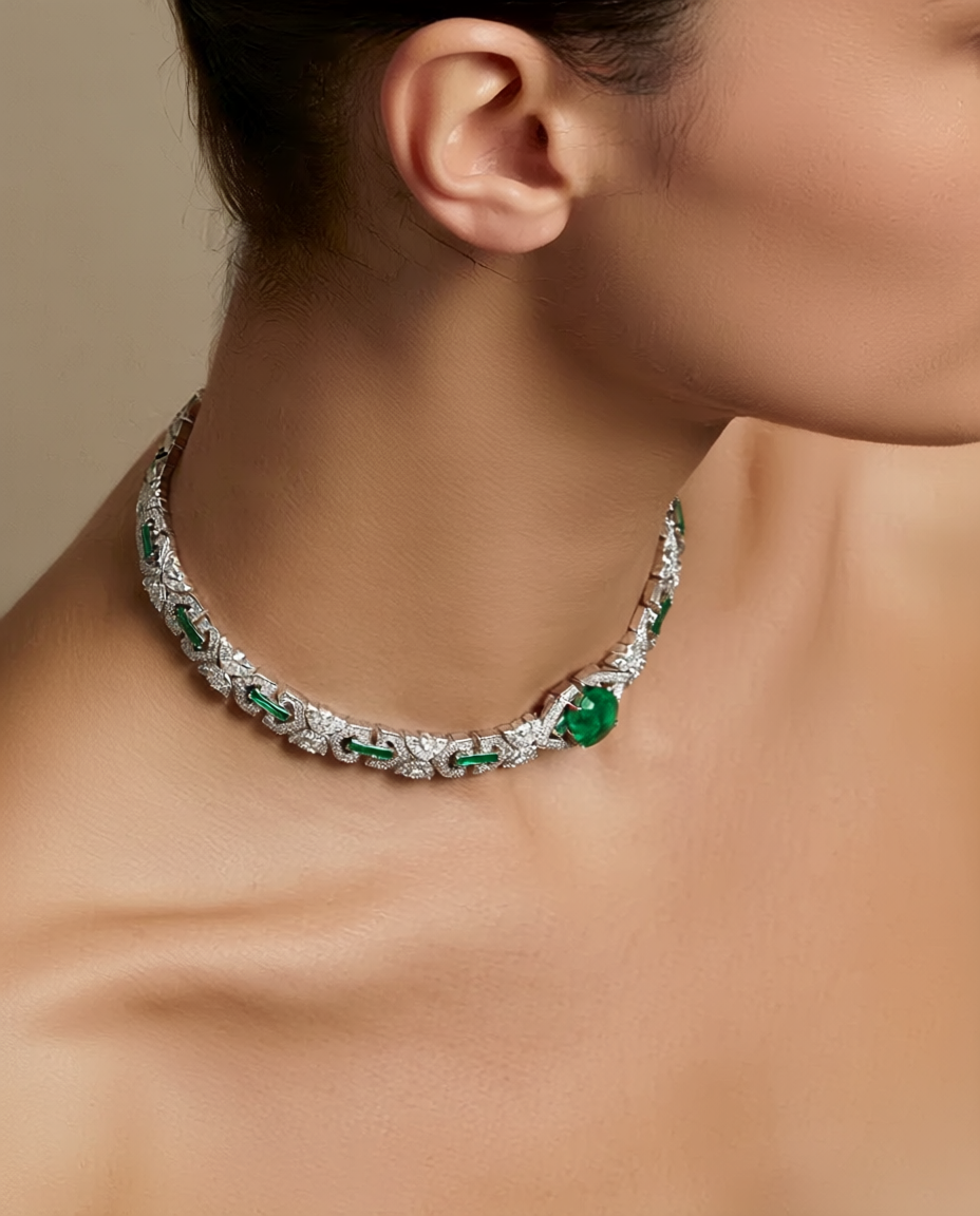 Close-up of a person wearing a necklace with green gemstones on a neutral background