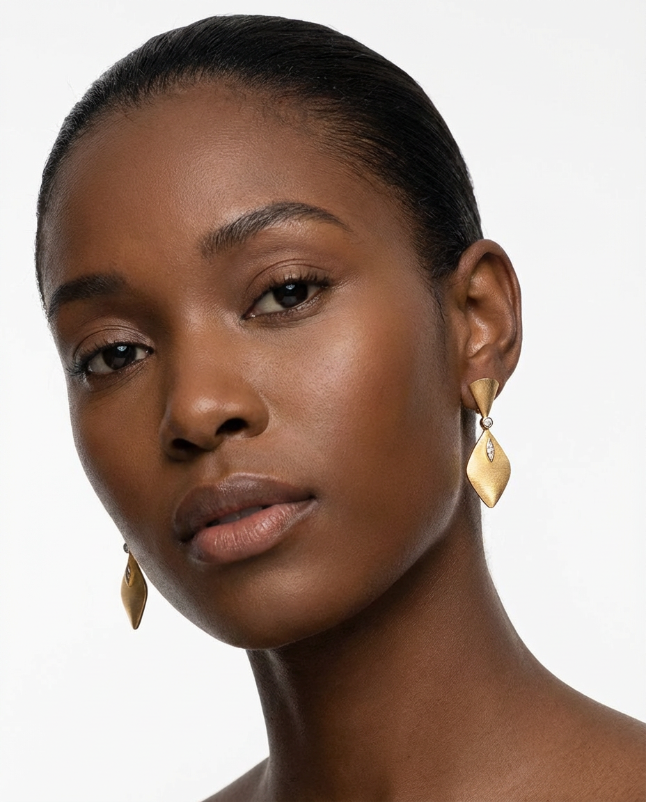 Close-up of a woman wearing gold earrings against a white background