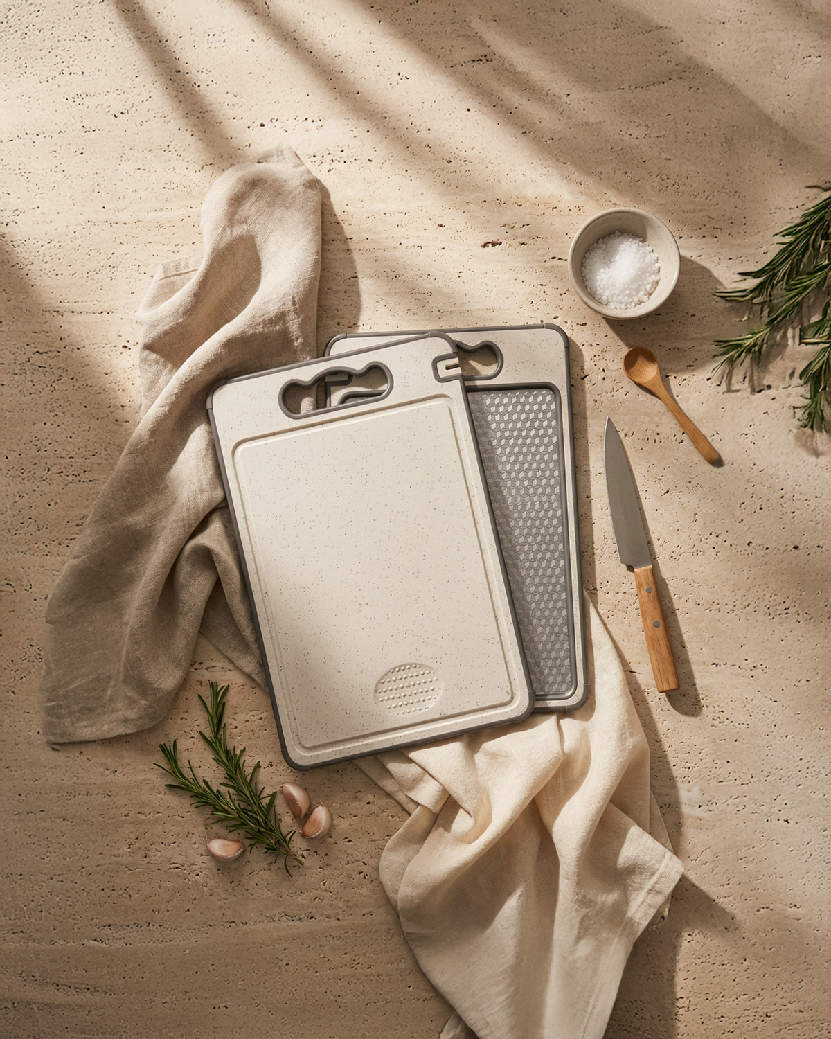 Set of cutting boards with a knife and towel on a wooden surface
