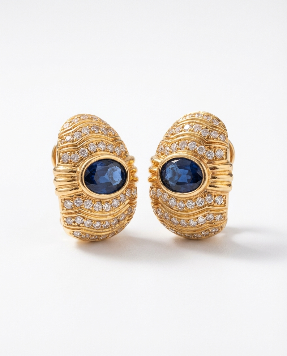 Pair of gold earrings with blue gemstones on a white background
