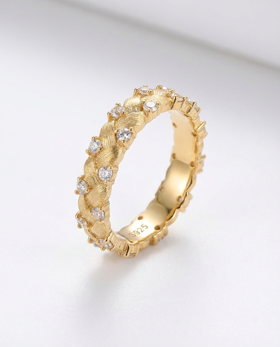 Gold ring with diamond accents on a light gray background