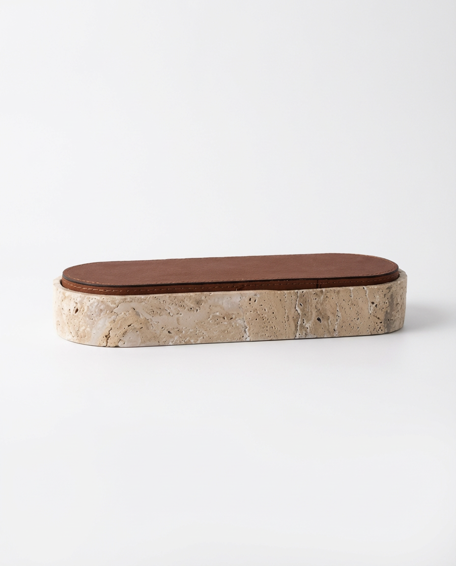 Rectangular stone soap dish with brown leather top on a white background