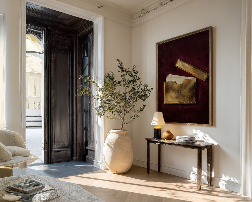 Modern interior with a vase, plant, and artwork on a wall.