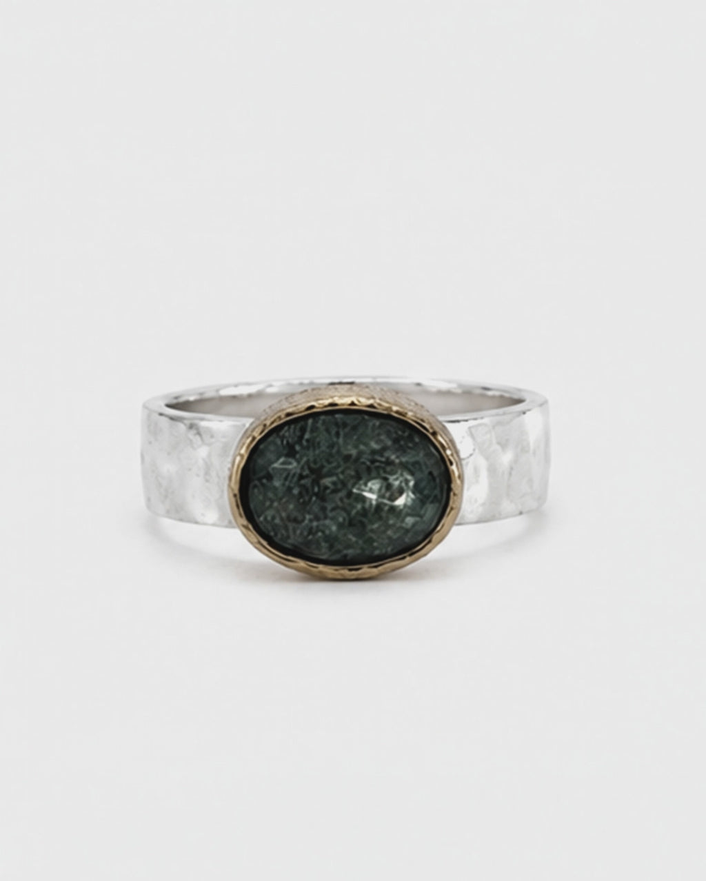Oval green gemstone signet ring featuring a polished sterling silver band and softly brushed gold bezel. The dark moss green faceted stone sits in a minimalist contemporary setting, photographed against a clean white background.