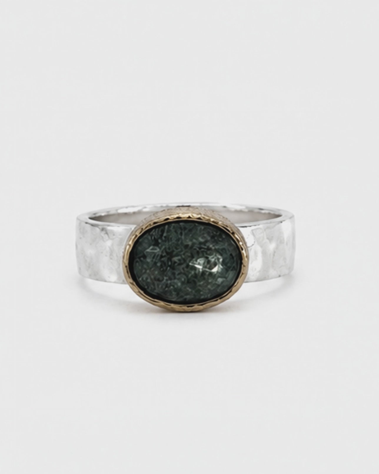 Oval green gemstone signet ring featuring a polished sterling silver band and softly brushed gold bezel. The dark moss green faceted stone sits in a minimalist contemporary setting, photographed against a clean white background.