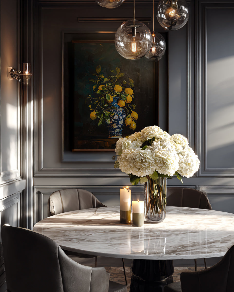Elegant interior with a marble table, vase of flowers, and framed artwork on a wall.