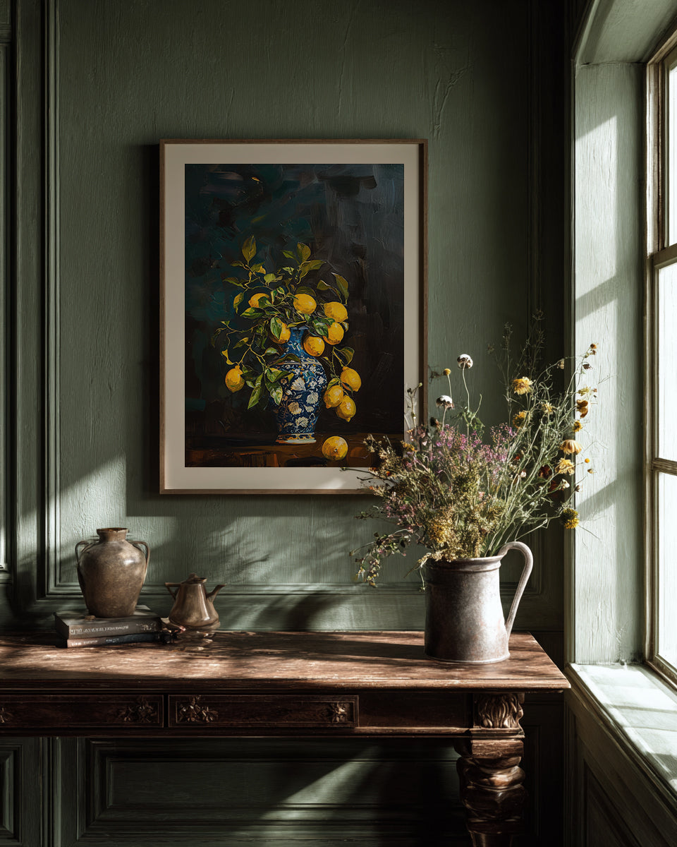 Framed painting of lemons on a wall with a wooden desk and vase in the foreground.