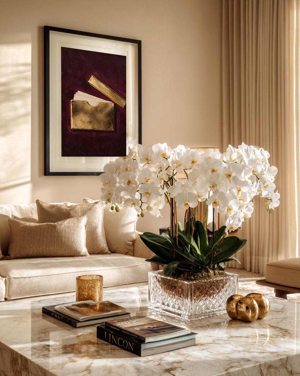 Living room with a marble coffee table, white orchids, and framed artwork.