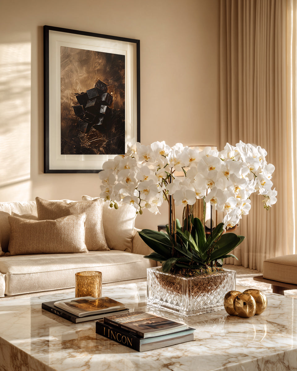 Living room with a marble coffee table, white orchids, and a framed picture on the wall.