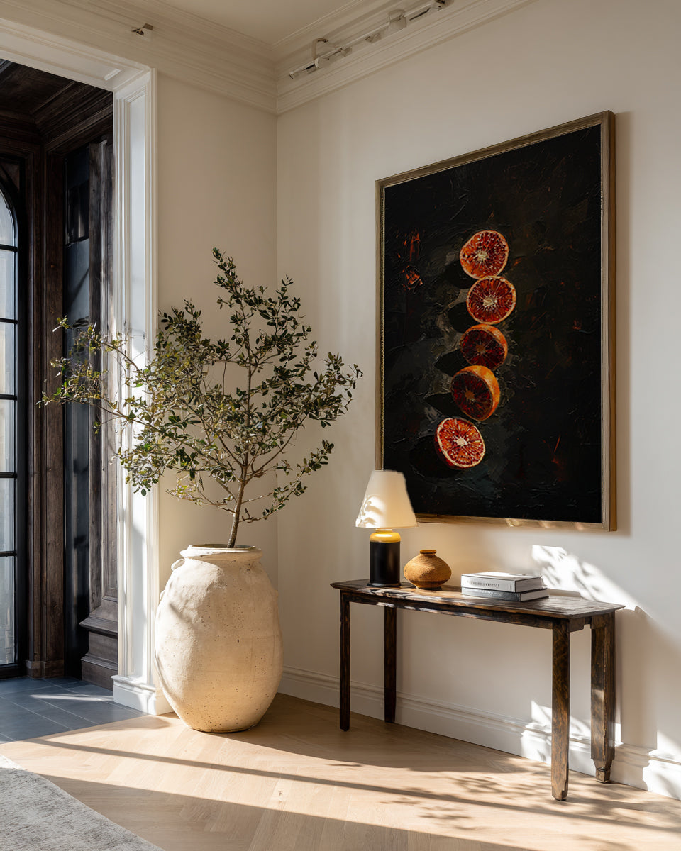 Modern interior with a vase, plant, and artwork on a wall.