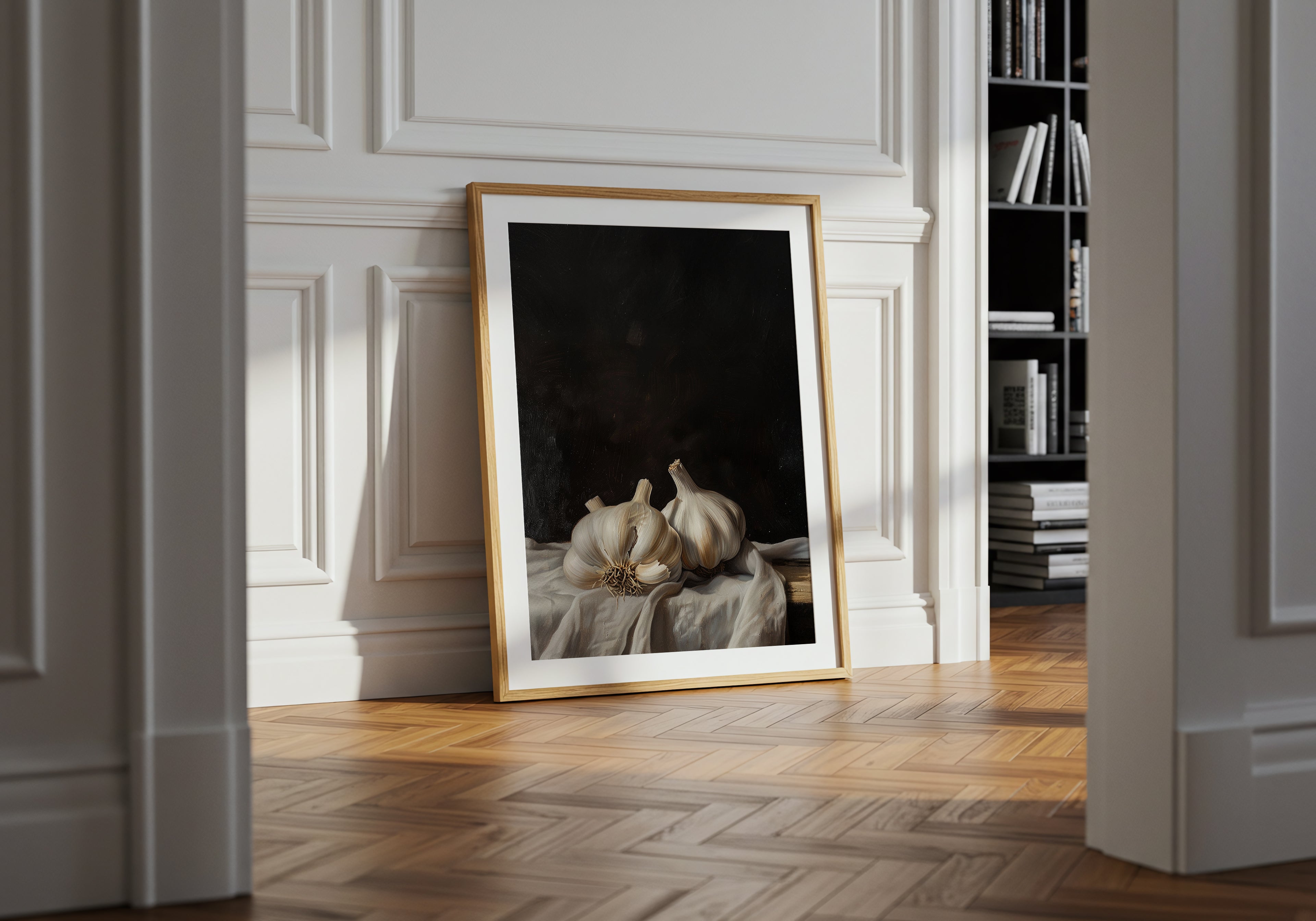 Framed artwork on a wall in a room with wooden flooring and a bookshelf.