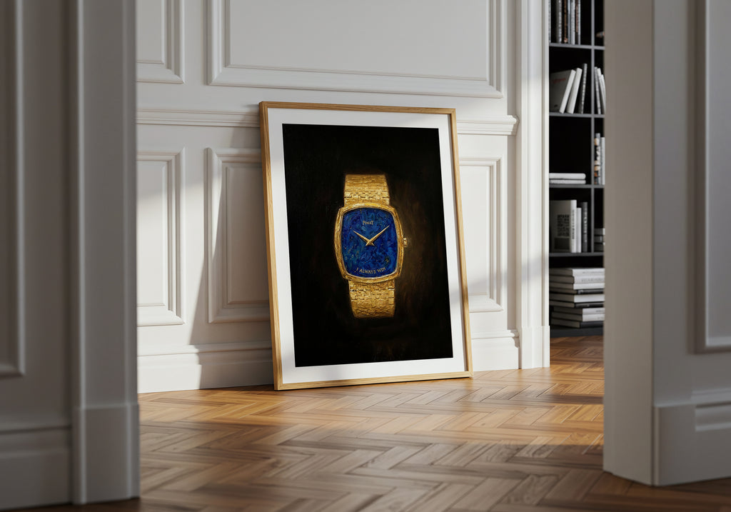 Framed picture of a gold watch on a wall in a room with wooden flooring and bookshelf.