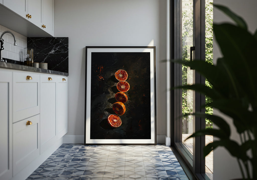 Framed artwork of sliced oranges on a dark background in a modern kitchen.