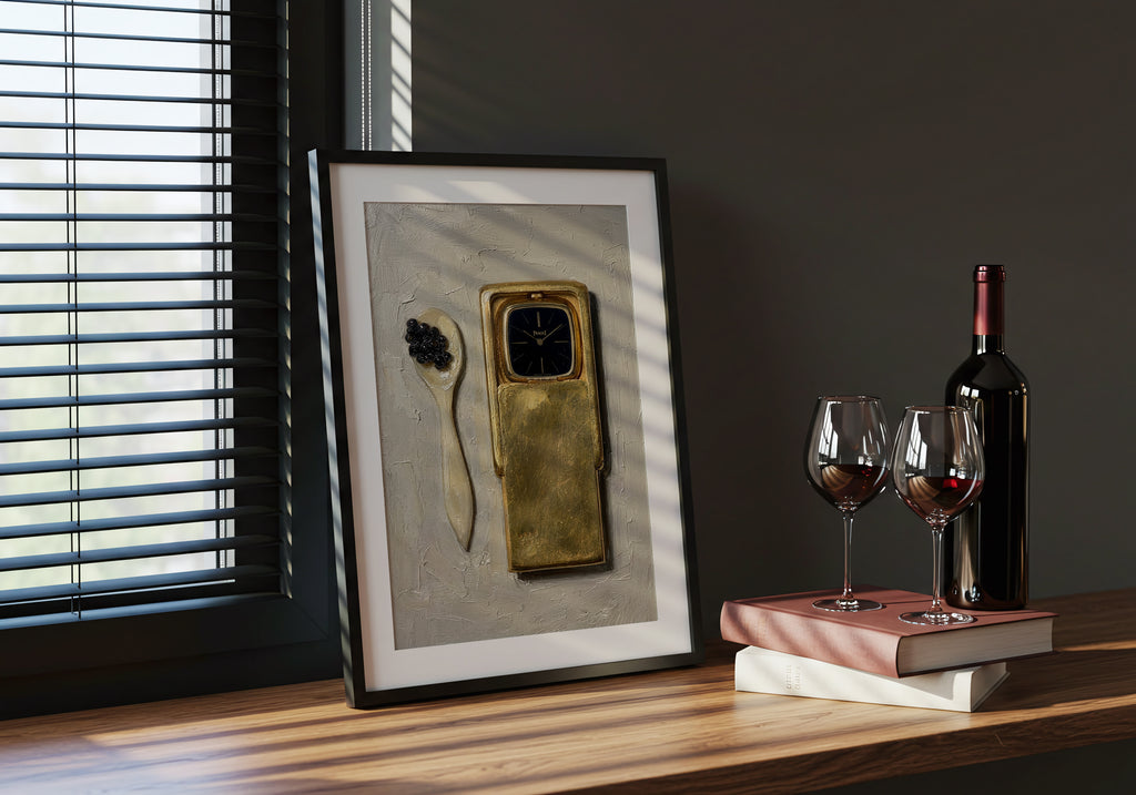 Framed artwork on a table with wine glasses and a bottle.